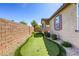 Beautiful backyard putting green is surrounded by desert landscaping, and is perfect for entertaining at 3122 Berceto Ct, Henderson, NV 89044