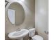 A powder bathroom featuring a pedestal sink and round decorative mirror at 3122 Berceto Ct, Henderson, NV 89044