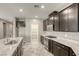 Modern kitchen features sleek, dark cabinetry, granite countertops, stainless steel appliances, and a center island with sink at 3122 Berceto Ct, Henderson, NV 89044
