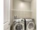 Modern laundry room with stainless steel washer and dryer set, and a wire shelf for storage at 3122 Berceto Ct, Henderson, NV 89044