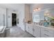 Bright bathroom featuring double sinks, white cabinetry, and access to a walk-in closet at 33 Reverie Heights Ave, Henderson, NV 89011