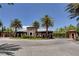 Community entrance with palm trees, stone accents, tile roof, and manicured landscaping at 33 Reverie Heights Ave, Henderson, NV 89011