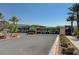 Gated community entrance with decorative stone pillars, manicured landscaping, and mountain views at 33 Reverie Heights Ave, Henderson, NV 89011