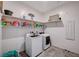 An organized laundry room with washer, dryer, and shelving at 33 Reverie Heights Ave, Henderson, NV 89011
