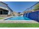 Stunning pool with blue tile waterfall feature and ample seating for entertaining on a sunny day at 33 Reverie Heights Ave, Henderson, NV 89011