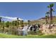 Beautiful waterfall cascading into a pond surrounded by palm trees at 33 Reverie Heights Ave, Henderson, NV 89011