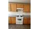 This kitchen features wood cabinets, plenty of counter space, and modern white appliances for cooking at 3425 Palatine Hills Ave, North Las Vegas, NV 89081