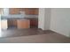 Kitchen view with wood cabinets, a central island, and access to a carpeted area for convenient living at 3425 Palatine Hills Ave, North Las Vegas, NV 89081