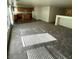 Spacious living room with carpet and adjacent kitchen featuring wood cabinets and a functional island at 3425 Palatine Hills Ave, North Las Vegas, NV 89081