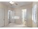 Bright bedroom featuring neutral paint, plantation shutters, and two open doorways at 3540 Wisdom Ct, Las Vegas, NV 89120