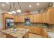 Spacious kitchen with custom wood cabinetry, island, granite counters, and tile floors at 3540 Wisdom Ct, Las Vegas, NV 89120