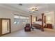 This main bedroom features a large four-poster bed, bedside tables, and a sitting area with a leather chair at 3540 Wisdom Ct, Las Vegas, NV 89120