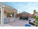 Charming backyard patio with tiki bar, outdoor seating, and shaded pergola is ideal for outdoor gatherings and entertaining at 3540 Wisdom Ct, Las Vegas, NV 89120