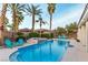 Sparkling pool with waterfall feature, surrounded by lush palms and lounge chairs for a tranquil backyard retreat at 3540 Wisdom Ct, Las Vegas, NV 89120