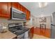 Updated kitchen with stainless steel microwave, range and wooden cabinets and a view to the dining area at 4390 Sandy River Dr # 1, Las Vegas, NV 89103