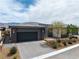 Modern single-story home with a dark gray garage and stone landscaping at 4531 S Bay Tree Ct, Pahrump, NV 89061