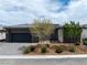 Contemporary home featuring a dark gray garage and low maintenance desert landscaping at 4531 S Bay Tree Ct, Pahrump, NV 89061