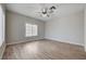 Bright bedroom features wood-look flooring, ceiling fan, and a window bringing in natural light at 4716 Cohiba Way, North Las Vegas, NV 89031