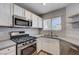 A bright kitchen featuring stainless appliances, white cabinets and a gas range at 4716 Cohiba Way, North Las Vegas, NV 89031