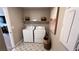 Functional laundry room with modern appliances, decorative tile flooring, and convenient shelving for storage at 5151 Capucina St # Lot 1, Las Vegas, NV 89122