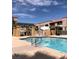 A community swimming pool bordered by lush tropical foliage and wrought iron fencing beneath a bright sunny sky at 5158 S Jones Blvd # 105, Las Vegas, NV 89118