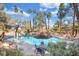 Enjoy the community pool featuring mature palm trees, tables and chairs at 5235 Caspian Springs St # 101, Las Vegas, NV 89120