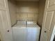 Bright laundry closet includes a stacked washer and dryer, plus shelving for organized storage at 5320 Portavilla Ct # 203, Las Vegas, NV 89122