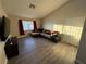 Living room featuring vaulted ceilings, a large window, and stylish laminate flooring at 5320 Portavilla Ct # 203, Las Vegas, NV 89122