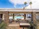 Relaxing poolside lounge area with a shaded structure, tables, benches, and a grill for outdoor cooking at 5841 Medallion Dr # 202, Las Vegas, NV 89122