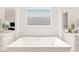 Bathroom featuring modern soaking tub between two vanities, tile floors and frosted window at 59 Reflection Bay Dr, Henderson, NV 89011