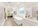 Bright bathroom with modern tub, white cabinets and tile floors; a spa-like retreat at 59 Reflection Bay Dr, Henderson, NV 89011