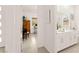 Hallway view of a workspace and a bathroom with white cabinets, creating a bright and welcoming space at 59 Reflection Bay Dr, Henderson, NV 89011
