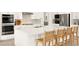 Close-up of kitchen island with marble countertops, modern fixtures, and seating for four at the counter at 59 Reflection Bay Dr, Henderson, NV 89011