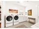 Bright laundry room featuring a modern washer and dryer with stylish wall art and neutral decor at 59 Reflection Bay Dr, Henderson, NV 89011