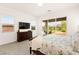 Bright main bedroom with access to the backyard, view of mountains, and a mounted TV at 59 Reflection Bay Dr, Henderson, NV 89011