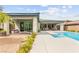 A covered patio leads to a gorgeous pool with colorful flowers, creating a relaxing outdoor space at 59 Reflection Bay Dr, Henderson, NV 89011