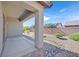 Covered back patio featuring a stone pillar. Low-maintenance gravel landscaping frames a brick wall at 6064 Isola Peak Ave, Las Vegas, NV 89122