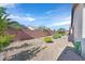 Landscaped backyard featuring a decorative block wall, desert landscaping, and a view of adjacent properties at 6064 Isola Peak Ave, Las Vegas, NV 89122