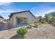 Cozy backyard featuring a covered patio, low-maintenance gravel landscaping, and several shrubbery accents at 6064 Isola Peak Ave, Las Vegas, NV 89122