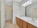 This bathroom has tile flooring, light wood vanity cabinets, double sinks, an attractive mirror, and a toilet at 6064 Isola Peak Ave, Las Vegas, NV 89122