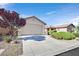 A single-Gathering home featuring a two-car garage, desert landscaping, and an extended driveway at 6064 Isola Peak Ave, Las Vegas, NV 89122