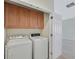 Dedicated laundry area with cabinets, appliances, and door to the adjacent room at 6064 Isola Peak Ave, Las Vegas, NV 89122
