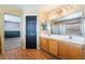 Spacious bathroom with double vanity, wood cabinets, and a large mirror reflecting the tub and shower at 6141 Babson Ave, Las Vegas, NV 89110
