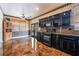 Modern kitchen featuring black cabinets, tile floors, and stainless steel appliances at 6141 Babson Ave, Las Vegas, NV 89110