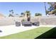 Relaxing backyard with a concrete patio, outdoor seating, and a well-maintained artificial grass lawn at 6198 Pinewood Ave, Las Vegas, NV 89103