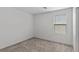 Bedroom with neutral walls and carpet featuring natural light from one window at 6955 Elysian Valley Ave, Las Vegas, NV 89113