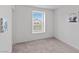 A simple bedroom with a window and carpeted floor creating a cozy space at 6955 Elysian Valley Ave, Las Vegas, NV 89113