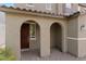 Arched entryway featuring brown front door, columned supports, and brick pavers at 6955 Elysian Valley Ave, Las Vegas, NV 89113