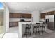 Kitchen with modern appliances, large island, three bar stools, and sliding doors to the exterior at 6955 Elysian Valley Ave, Las Vegas, NV 89113