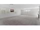 Large living room featuring neutral carpeting and white walls with modern recessed lighting and a bright window at 6955 Elysian Valley Ave, Las Vegas, NV 89113